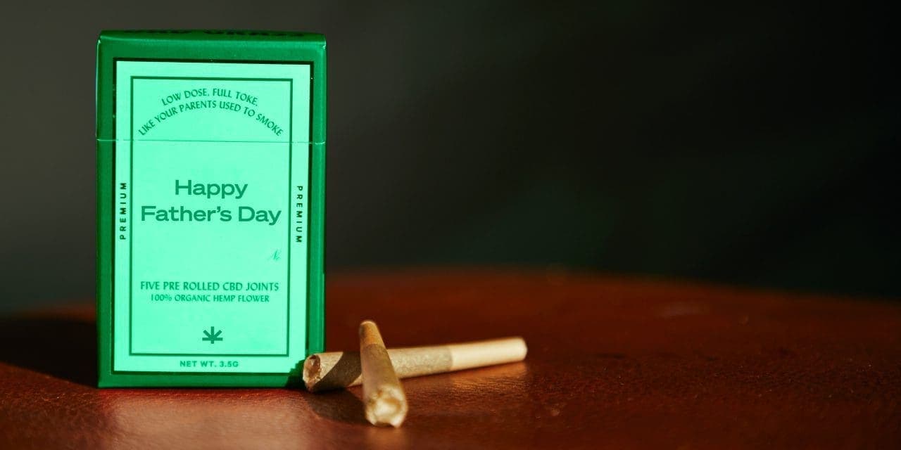 a box of pre rolled CBD joints and two pre rolled joints outside of it
